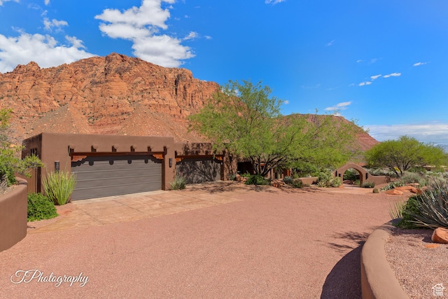 1936 N Uwan Dr, Ivins, UT 84738 - view of front of property featuring an attached garage, a mountain view, driveway, and stucco siding