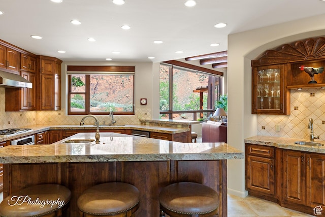 1936 N Uwan Dr, Ivins, UT 84738 - kitchen with recessed lighting, decorative backsplash, a sink, a kitchen bar, and healthy amount of natural light