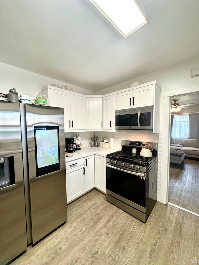 52 W 2000 N, Sunset, UT 84015 - kitchen featuring appliances with stainless steel finishes, white cabinetry, light wood-style floors, and decorative backsplash