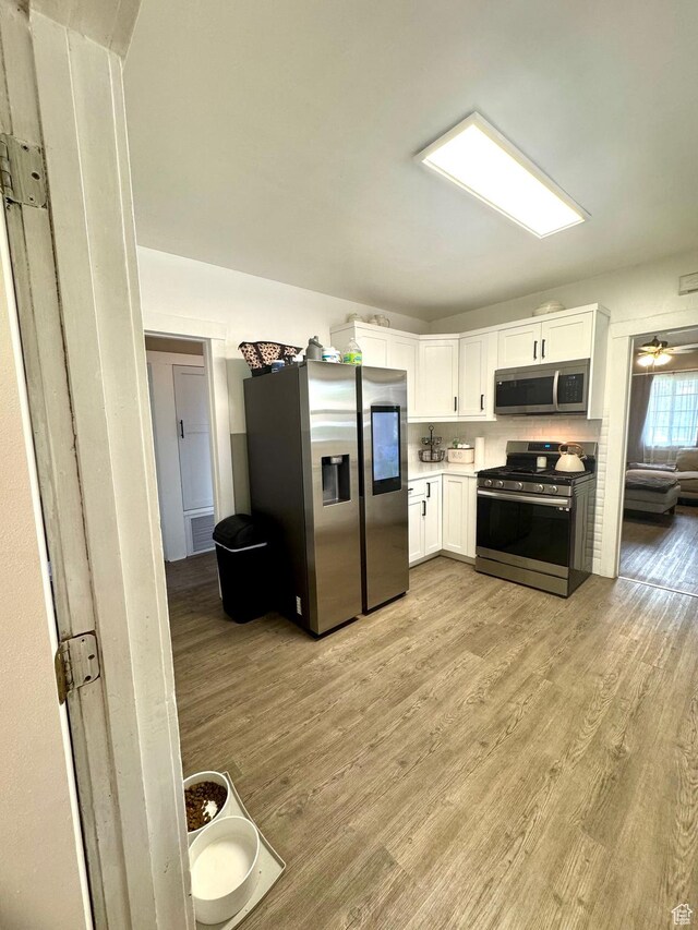 52 W 2000 N, Sunset, UT 84015 - kitchen featuring stainless steel appliances, light wood-type flooring, white cabinets, and light countertops