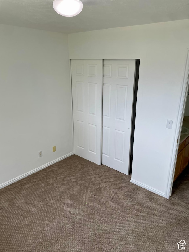 6939 S Florentine Way, West Jordan, UT 84084 - unfurnished bedroom with dark colored carpet, a closet, and baseboards