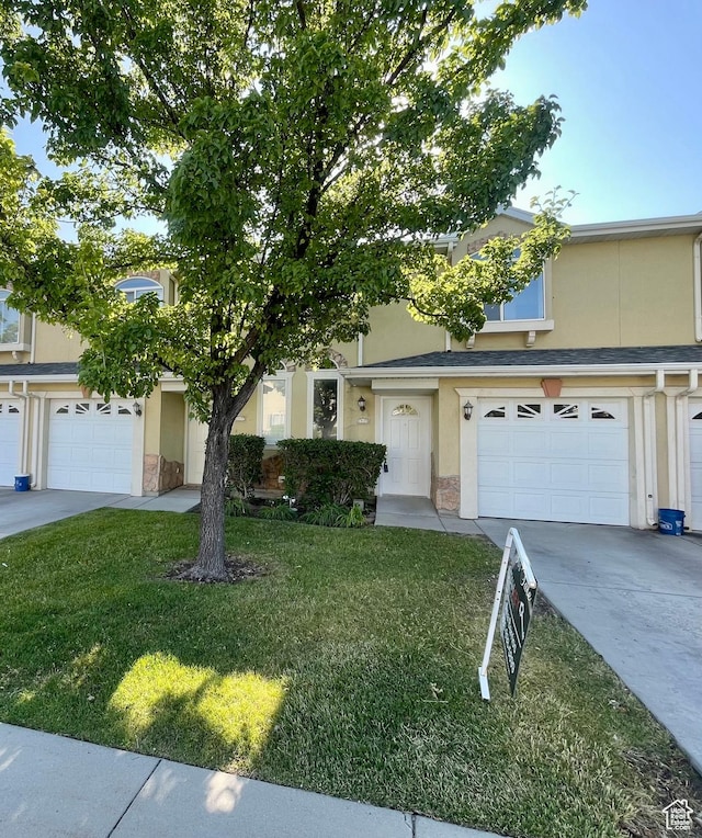 6939 S Florentine Way, West Jordan, UT 84084 - view of front of house with stucco siding, stone siding, a front yard, concrete driveway, and a garage