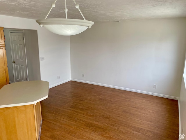 6939 S Florentine Way, West Jordan, UT 84084 - unfurnished dining area with dark wood finished floors, baseboards, and a textured ceiling