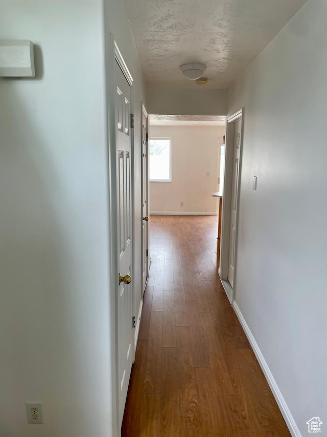 6939 S Florentine Way, West Jordan, UT 84084 - hallway featuring dark wood-type flooring, baseboards, and a textured ceiling