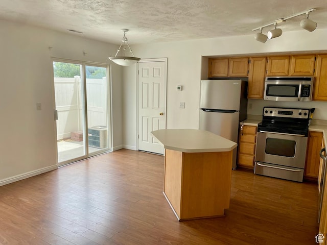 6939 S Florentine Way, West Jordan, UT 84084 - kitchen with appliances with stainless steel finishes, light countertops, hardwood / wood-style flooring, hanging light fixtures, and a textured ceiling