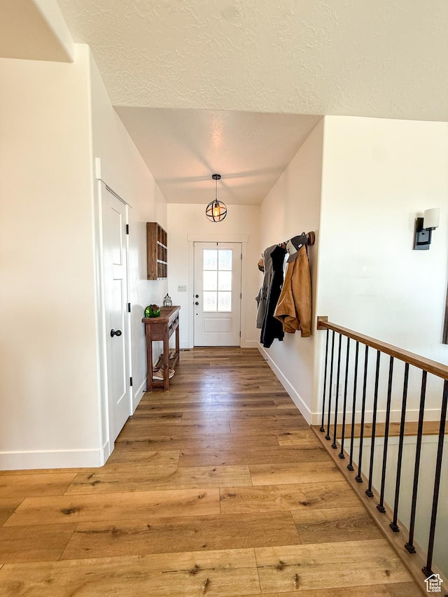 1384 E Abigail Ln, Eagle Mountain, UT 84005 - entryway with light wood-type flooring, baseboards, and a textured ceiling