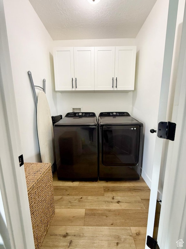 1384 E Abigail Ln, Eagle Mountain, UT 84005 - laundry room with cabinet space, washing machine and dryer, light wood finished floors, and a textured ceiling