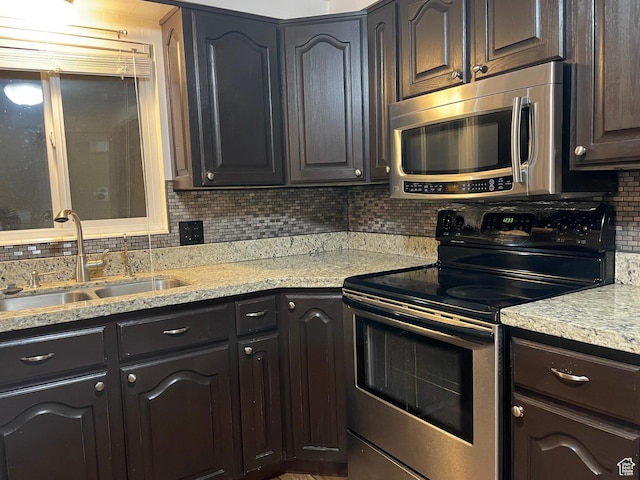 4380 S Perigrine Way, West Valley City, UT 84120 - kitchen with stainless steel appliances, a sink, backsplash, and light stone countertops