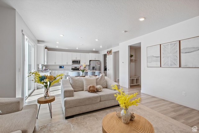 2503 N Velvet Moon Dr W Unit 636, Saratoga Springs, UT 84045 - living area with light wood-style flooring, a textured ceiling, recessed lighting, and baseboards