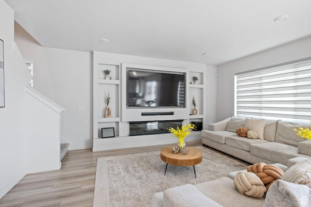 2503 N Velvet Moon Dr W Unit 636, Saratoga Springs, UT 84045 - living area with stairs, light wood-type flooring, built in features, a textured ceiling, and baseboards