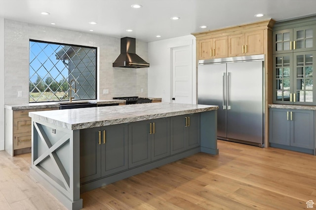 3248 E 5225 N Unit 5, Liberty, UT 84310 - kitchen featuring wall chimney range hood, built in refrigerator, decorative backsplash, a center island, and light wood-style flooring