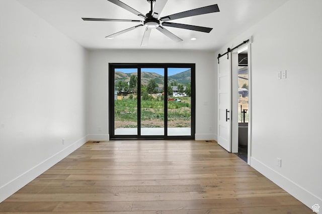 3248 E 5225 N Unit 5, Liberty, UT 84310 - spare room with a barn door, a mountain view, light wood-style flooring, ceiling fan, and recessed lighting