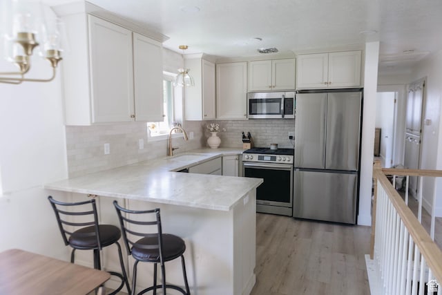 354 S 1100 E, Springville, UT 84663 - kitchen with appliances with stainless steel finishes, a sink, a peninsula, and white cabinetry