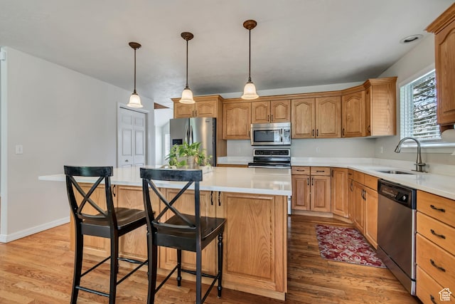 2825 Elk Horn Ln, Cottonwood Heights, UT 84093 - kitchen featuring appliances with stainless steel finishes, a sink, light wood-type flooring, a center island, and a breakfast bar
