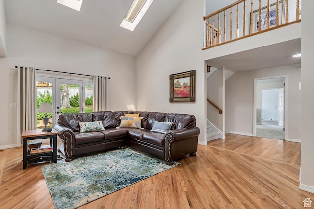 2825 Elk Horn Ln, Cottonwood Heights, UT 84093 - living area with high vaulted ceiling, stairs, a skylight, light wood-style floors, and baseboards