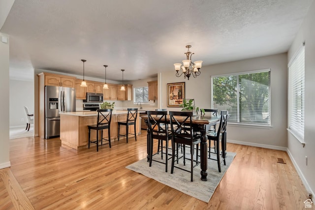 2825 Elk Horn Ln, Cottonwood Heights, UT 84093 - dining room with plenty of natural light, a chandelier, light wood-style floors, baseboards, and a textured ceiling