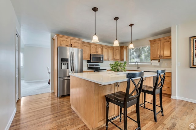 2825 Elk Horn Ln, Cottonwood Heights, UT 84093 - kitchen featuring appliances with stainless steel finishes, a center island, light wood-type flooring, a kitchen breakfast bar, and baseboards