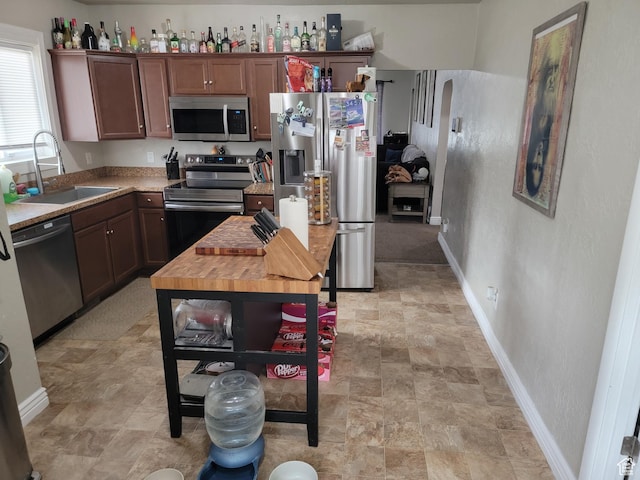 853 E 27th St, Ogden, UT 84403 - kitchen featuring appliances with stainless steel finishes, a sink, stone finish floors, and baseboards