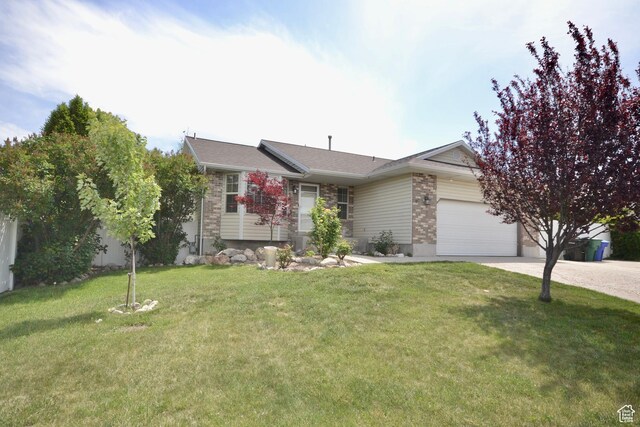 5057 W 6960 S, West Jordan, UT 84081 - view of front of home featuring an attached garage, concrete driveway, a front yard, and brick siding