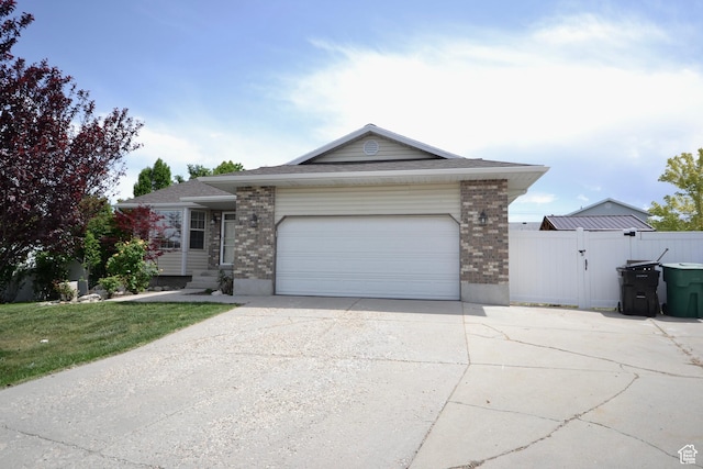5057 W 6960 S, West Jordan, UT 84081 - ranch-style house with brick siding, concrete driveway, a garage, and a gate