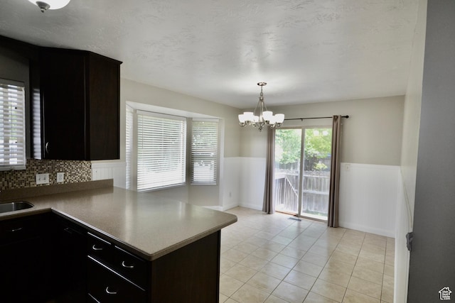 5057 W 6960 S, West Jordan, UT 84081 - kitchen with wainscoting, a chandelier, a sink, a peninsula, and light tile patterned floors