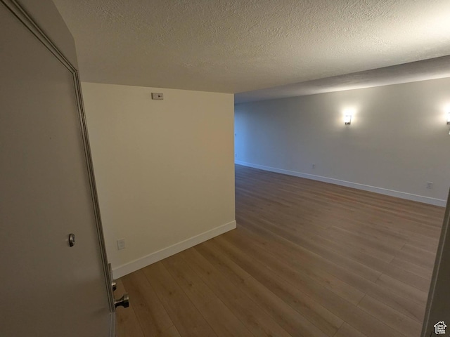 241 N Vine St W Unit 404E, Salt Lake City, UT 84103 - unfurnished room with wood finished floors, baseboards, and a textured ceiling