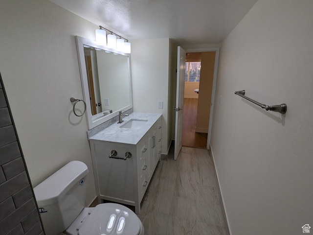 241 N Vine St W Unit 404E, Salt Lake City, UT 84103 - bathroom with toilet, vanity, marble look tile flooring, and baseboards