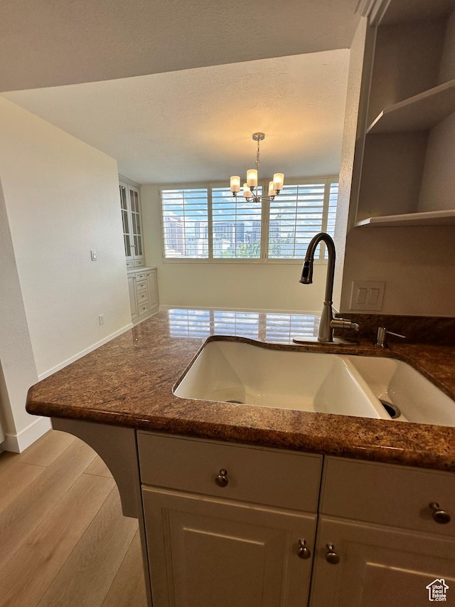 241 N Vine St W Unit 404E, Salt Lake City, UT 84103 - kitchen featuring a sink, dark stone counters, a chandelier, baseboards, and open shelves
