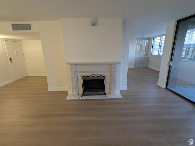 241 N Vine St W Unit 404E, Salt Lake City, UT 84103 - unfurnished living room with wood finished floors, a chandelier, a premium fireplace, and baseboards