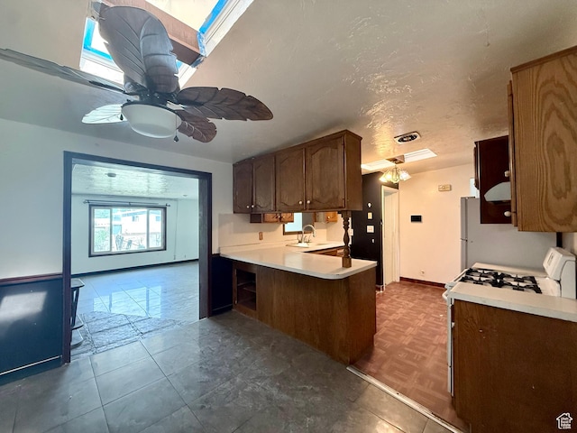 4203 S 4900 W, West Valley City, UT 84120 - kitchen with light countertops, a sink, ceiling fan, a peninsula, and white appliances