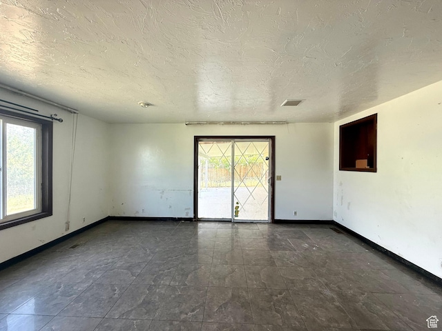 4203 S 4900 W, West Valley City, UT 84120 - spare room featuring plenty of natural light, baseboards, and a textured ceiling