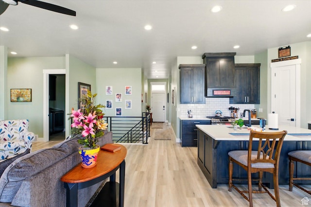 653 S 1140 E, Smithfield, UT 84335 - kitchen featuring light countertops, a breakfast bar, premium range hood, light wood-style flooring, and recessed lighting