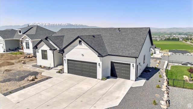 653 S 1140 E, Smithfield, UT 84335 - view of front of home with driveway, a shingled roof, a mountain view, and a garage
