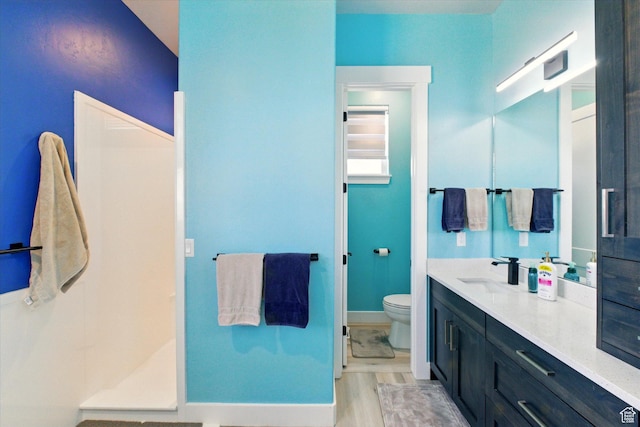 653 S 1140 E, Smithfield, UT 84335 - bathroom with toilet, vanity, baseboards, a shower, and wood finished floors