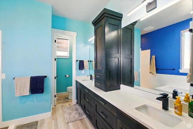 653 S 1140 E, Smithfield, UT 84335 - bathroom featuring toilet, double vanity, wood finished floors, and baseboards