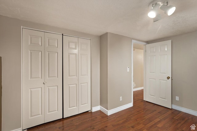 2263 W 4400 S, Roy, UT 84067 - unfurnished bedroom featuring a textured ceiling, dark wood-style flooring, baseboards, and a closet