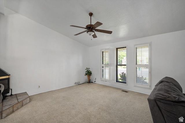2263 W 4400 S, Roy, UT 84067 - living area with carpet floors, vaulted ceiling, a ceiling fan, and a wood stove