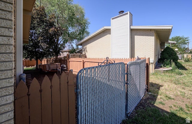2263 W 4400 S, Roy, UT 84067 - view of side of home with a gate, a chimney, and brick siding