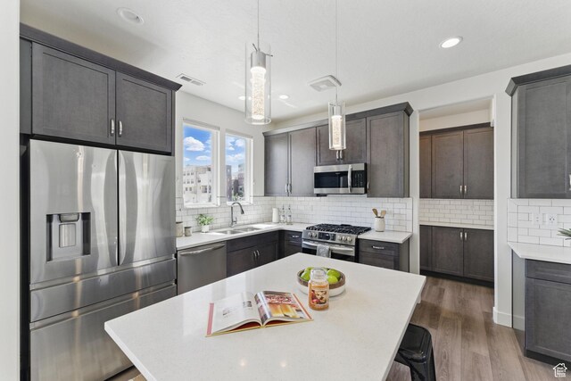 11398 Lake Run Rd, South Jordan, UT 84095 - kitchen with appliances with stainless steel finishes, a sink, light countertops, tasteful backsplash, and dark wood-style flooring