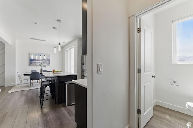 11398 Lake Run Rd, South Jordan, UT 84095 - kitchen featuring dark wood finished floors, light countertops, a kitchen bar, a center island, and baseboards