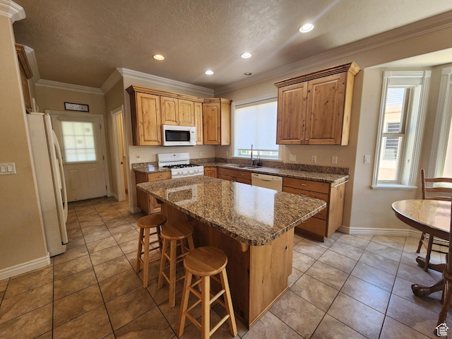 3368 N 700 E, Lehi, UT 84043 - kitchen featuring white appliances, a sink, baseboards, a kitchen breakfast bar, and a center island