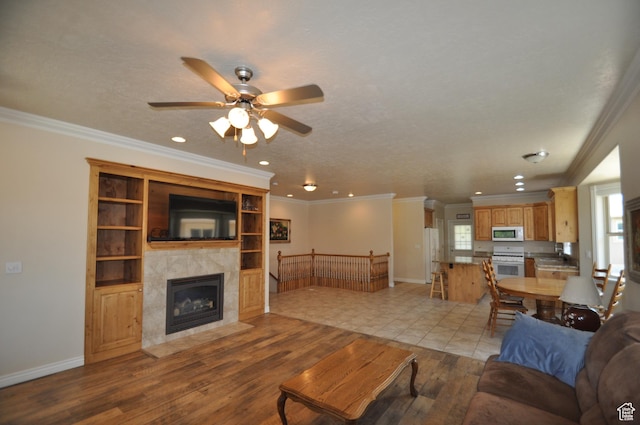 3368 N 700 E, Lehi, UT 84043 - living room featuring light wood finished floors, ceiling fan, recessed lighting, a tile fireplace, and plenty of natural light
