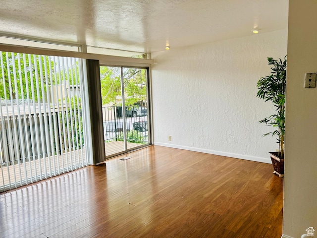 4419 S Rosehaven Ct Unit A, West Valley City, UT 84120 - empty room with a textured wall, wood finished floors, and baseboards