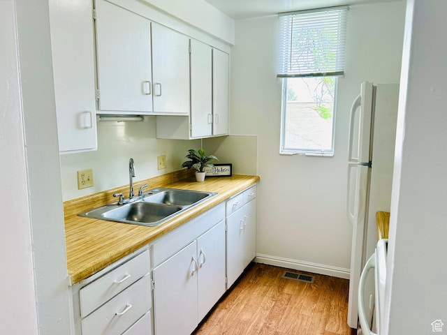 4419 S Rosehaven Ct Unit A, West Valley City, UT 84120 - kitchen featuring a sink, light countertops, light wood-style flooring, and white cabinetry