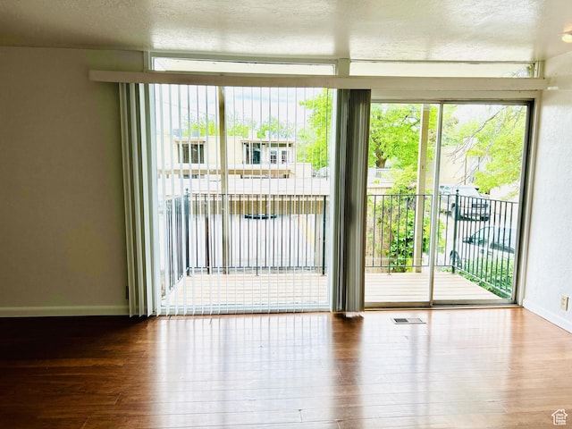 4419 S Rosehaven Ct Unit A, West Valley City, UT 84120 - spare room with hardwood / wood-style flooring, baseboards, and a textured ceiling