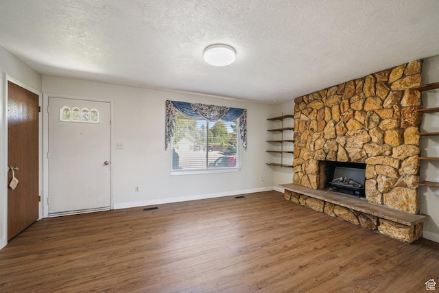 621 N 100 W, American Fork, UT 84003 - unfurnished living room featuring a textured ceiling, wood finished floors, a fireplace, and baseboards