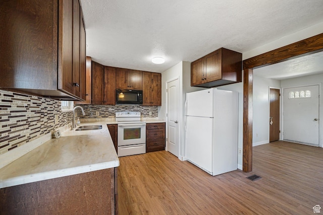 621 N 100 W, American Fork, UT 84003 - kitchen with white appliances, a sink, backsplash, light wood-type flooring, and light countertops