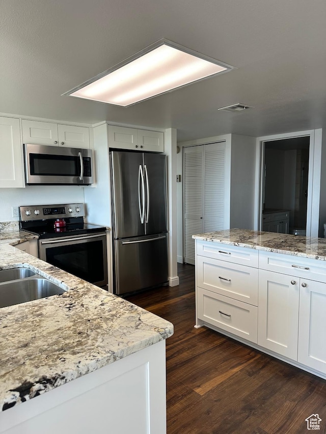 241 N Vine St E Unit 207W, Salt Lake City, UT 84103 - kitchen with appliances with stainless steel finishes, white cabinetry, dark wood finished floors, and light stone countertops