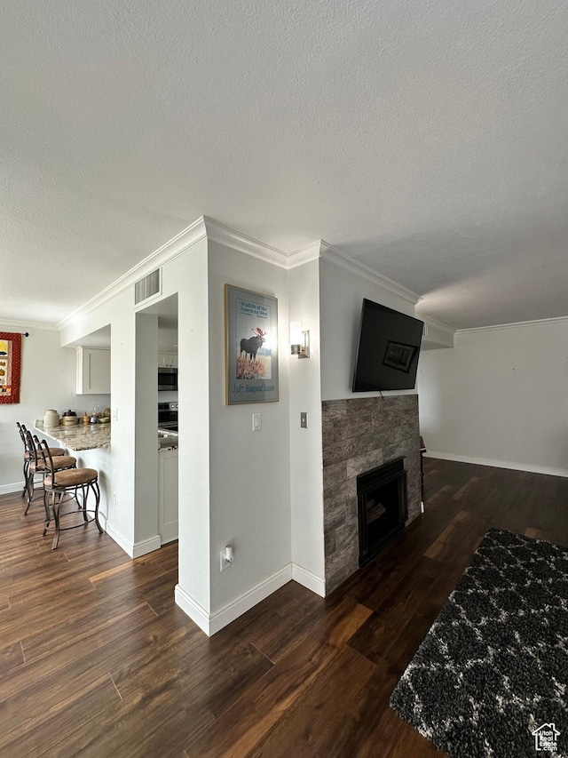 241 N Vine St E Unit 207W, Salt Lake City, UT 84103 - living room featuring a textured ceiling, ornamental molding, wood finished floors, a fireplace, and baseboards