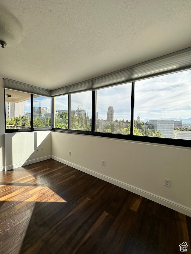 241 N Vine St E Unit 207W, Salt Lake City, UT 84103 - unfurnished room with dark wood-style flooring, a view of city, and a textured ceiling